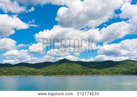 Summer view of local lake Cave Run with beautiful forest on lake hillside shore and dramatic cloudscape sky in Kentucky USA