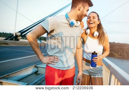 Portrait of hadsome man and beautiful woman during break of jogging