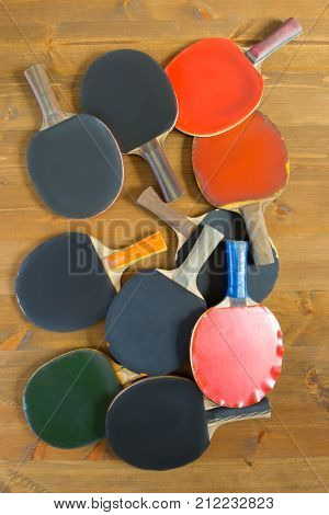 large number of old rackets lies on a wooden background