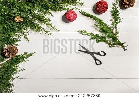 Juniper branches with a Christmas decor. Christmas, New Year background. Coniferous branches of juniper. Top view, flat design. Christmas tree on white wooden background.