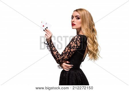 Beautiful blonde in a black dress with casino cards two aces in hands isolated on a white background. Poker. Casino. Roulette Blackjack Spin. Caucasian young woman looking at the camera. Winning combination