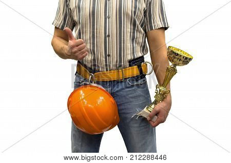 Builder construction worker in mounting belt and with helmet holding in hands golden cup award trophy. Awards ceremony. Best builder worker of the year. Success in construction and repair.