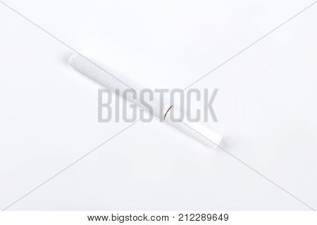White cigarette on white background. Tobacco cigarette with filter isolated on white background. Smoking and nicotine concept.