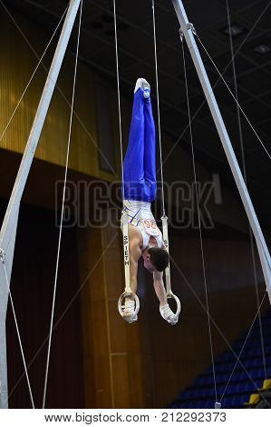 Male Gymnast Performing On Stationary Gymnastic Rings