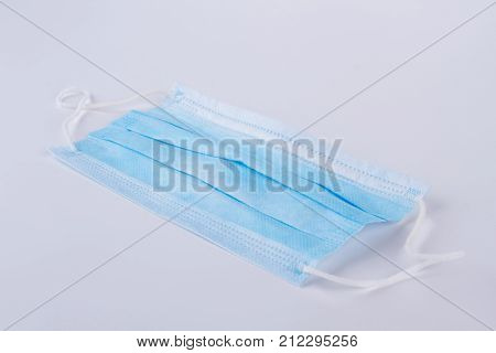 Medical face mask, grey background. Blue medical potective bandage isolated on grey background. Health care and hospital concept.