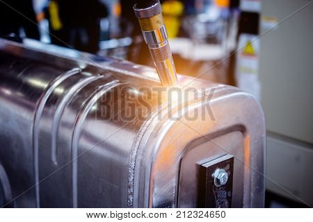 Automatic welding machine produces welding of a metal tank. Close-up photo.