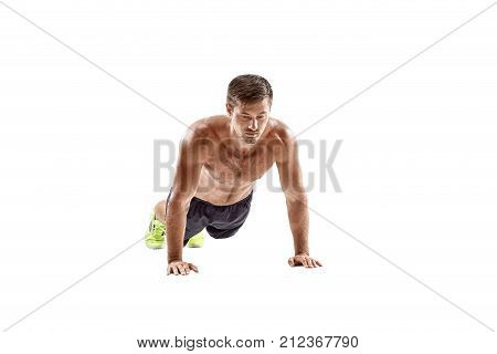 Push up fitness man doing push-up bodyweight exercise on gym floor. Athlete working out chest muscles strength training indoors. Horizontal. Copy space