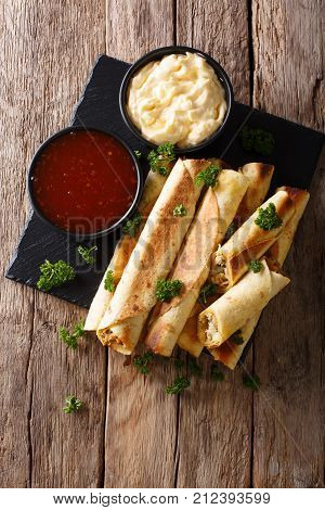 Mexican Taquitos With Chicken And Cheese Stuffing Close-up, And Sauces. Vertical Top View