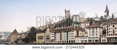 LUCERNE SWITZERLAND - FEBRUARY 07 2010: View of Lucerne fortress walls with towers and embankment of the Reuss in the winter cloudy day
