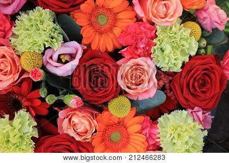 Mixed flower arrangement: various flowers in different shades of red pink and orange