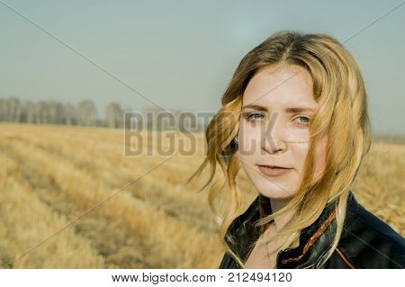 Beautiful Russian girl with blond hair in the field