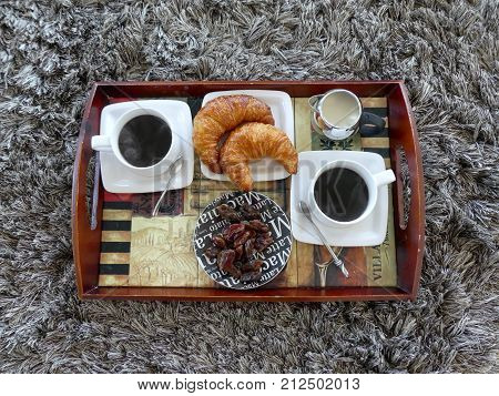 Top view crossant  two cups of coffee  dates creme