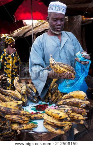 BAMAKO, MALI - CIRCA FEBRUARY 2012: Shopkeeper selling plantain at one of the city's market.