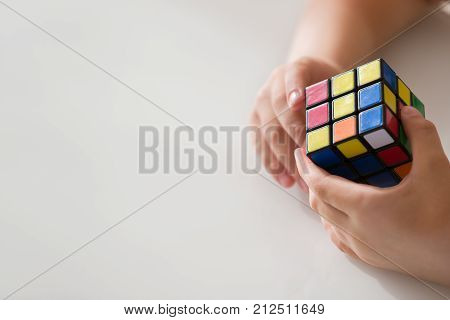 Moscow Russia August 16 2017: Rubik's cube in child's hands closeup. Boy holding Rubik's cube and playing with it.
