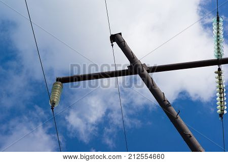 High electric pole with glass gaps on the sky background