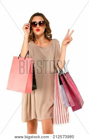 Shopper Woman In Dress With Shopping Bags Shows Two Fingers And Sends Air Kiss.