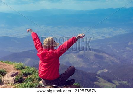 tourist with the opened and raised hands up on the background majestic mountains