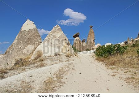 Natural valley with volcanic tuff stone rocks dramatically lit by a sun in Chavushin in Cappadocia Central Anatolia region of Turkey. Popular tourist destination in Turkey for trekking.