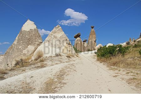 Natural valley with volcanic tuff stone rocks dramatically lit by a sun in Chavushin in Cappadocia Central Anatolia region of Turkey. Popular tourist destination in Turkey for trekking.