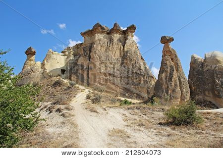 Natural valley with volcanic tuff stone rocks dramatically lit by a sun in Chavushin in Cappadocia Central Anatolia region of Turkey. Popular tourist destination in Turkey for trekking.