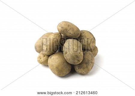 Pile of raw potatoes on a white background. Tubers of fresh, dirty potatoes close-up