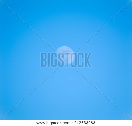 The moon in the day in a clear blue sky