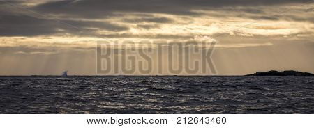Sunbeams over sea, with warm sky and blue ocean. Skagerrak, Norway