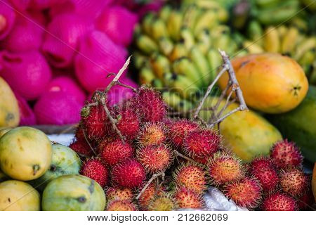 Assortment of fresh exotic rambutan fruits on market stall