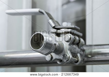 Ball valve stainless steel. The valve is mounted on a horizontal metal pipe.