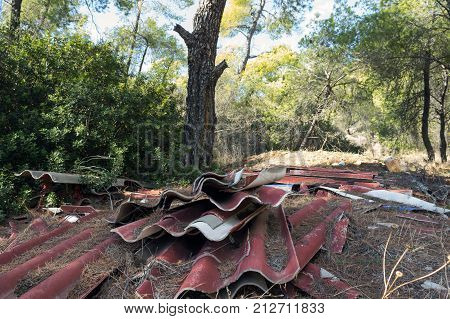 Pollution of the forest by household rubbish. A pile of garbage in the forest. Global problem of pollution.