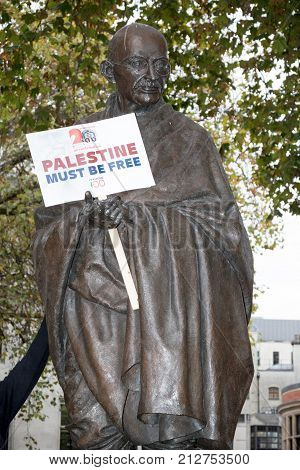4th November 2017 London United Kingdom:-Statue of Mahatma Gandhi in Parliment square holding a pro Palestine placard placed by protesters