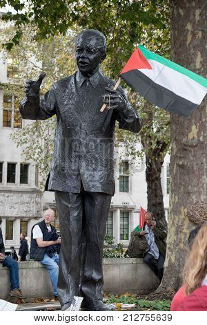 4th November 2017 London United Kingdom:-Statue of Nelson Mandela holding a Palestine flag placed by a protester in Parliment Square