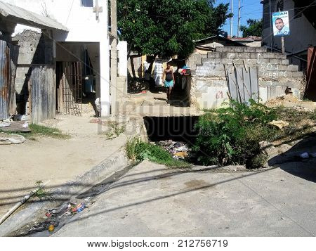 SANTO DOMINGO DOMINICAN REPUBLIC - OCT 25 2015: Poor pregnant woman walking on an outfall in Santo Domingo Dominican Republic.