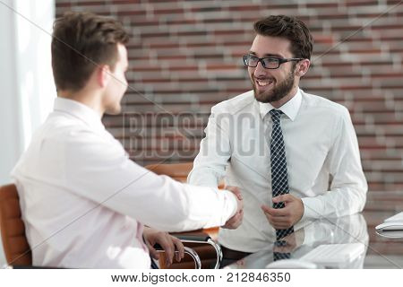 handshake colleagues sitting at your Desk