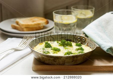 Omelette With Broccoli And Cheese Served With Bread Toasts And Lemonade.