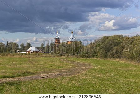Rural summer landscape with wooden church. Church of the Nativity Prophet and Predtechi John the Baptist in the village Zaruchevnya (Shilovskaya), Velsk district, Arkhangelsk region, Russia