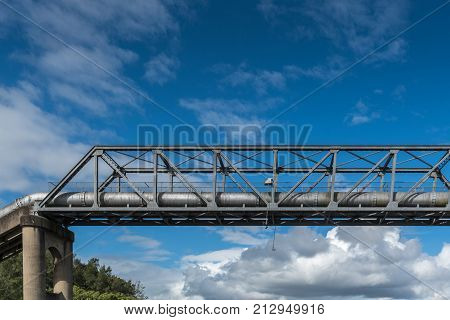 Parramatta Australia - March 24 2017: Closeup of part of Thackeray Street gray metal pipeline bridge over Parramatta River under blue sky with cloudscape.