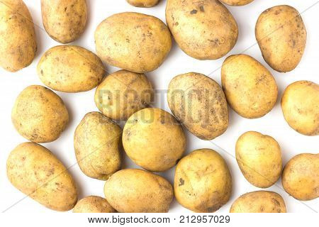 A lot of potatoes lie on a white background. View from above.