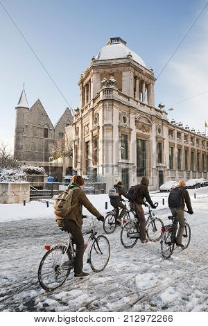 GHENT BELGIUM - CIRCA 2010: School children cycling in winter through the streets of Ghent Belgium