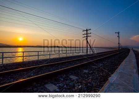 rail way track over water reservoir and beautiful sun set sky