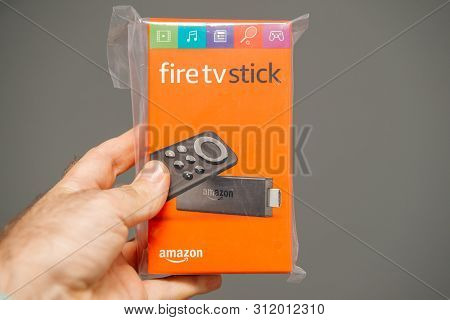 Paris, France - Jul 15, 2019: Man Hand Holding New Plastic Wrapped New Amazon Fire Tv Stick With Ale