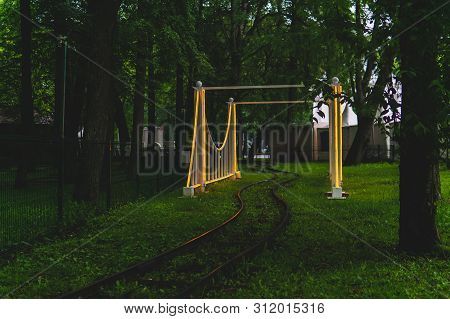 Rails And Arch Of The Narrow Gauge Railway In The Evening Amusement Park