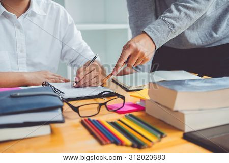 High School Or College Students Studying And Reading Together In Library