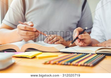 High School Or College Students Studying And Reading Together In Library
