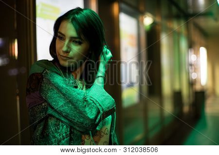 Beautiful Girl Street Portrait. Green Neon Light, She's Wearing An Alien Shirt