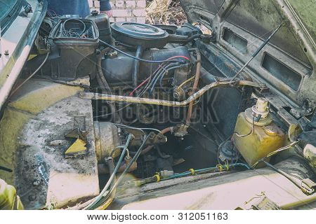 The Engine Compartment Of The Car. Old Dirty Engine