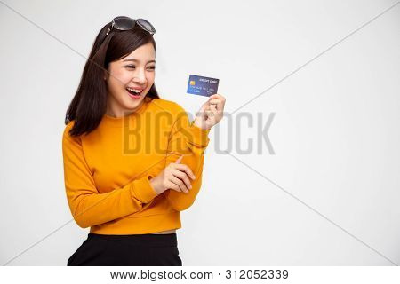 Happy Asian Woman In Yellow Shirt Holding Credit Card Or Cash Advances, Pay Instead Of Money And Spe