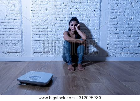 Sad Woman Or Teenager Girl Afraid Of Weight Looking At Scale In Nutrition Disorder
