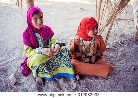 Egypt, Hurghada, 12 May 2019, Two Little Girls Sitting On The Ground In The Beduin Village