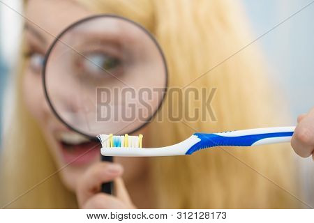 Beautiful Perfectionist Young Woman Checking Her Tooth Brush Through Manifying Loupe Glass. Hygiene,